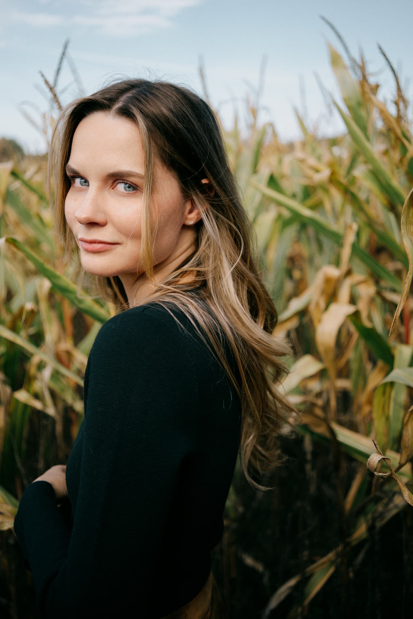 Woman looking back in a cornfield