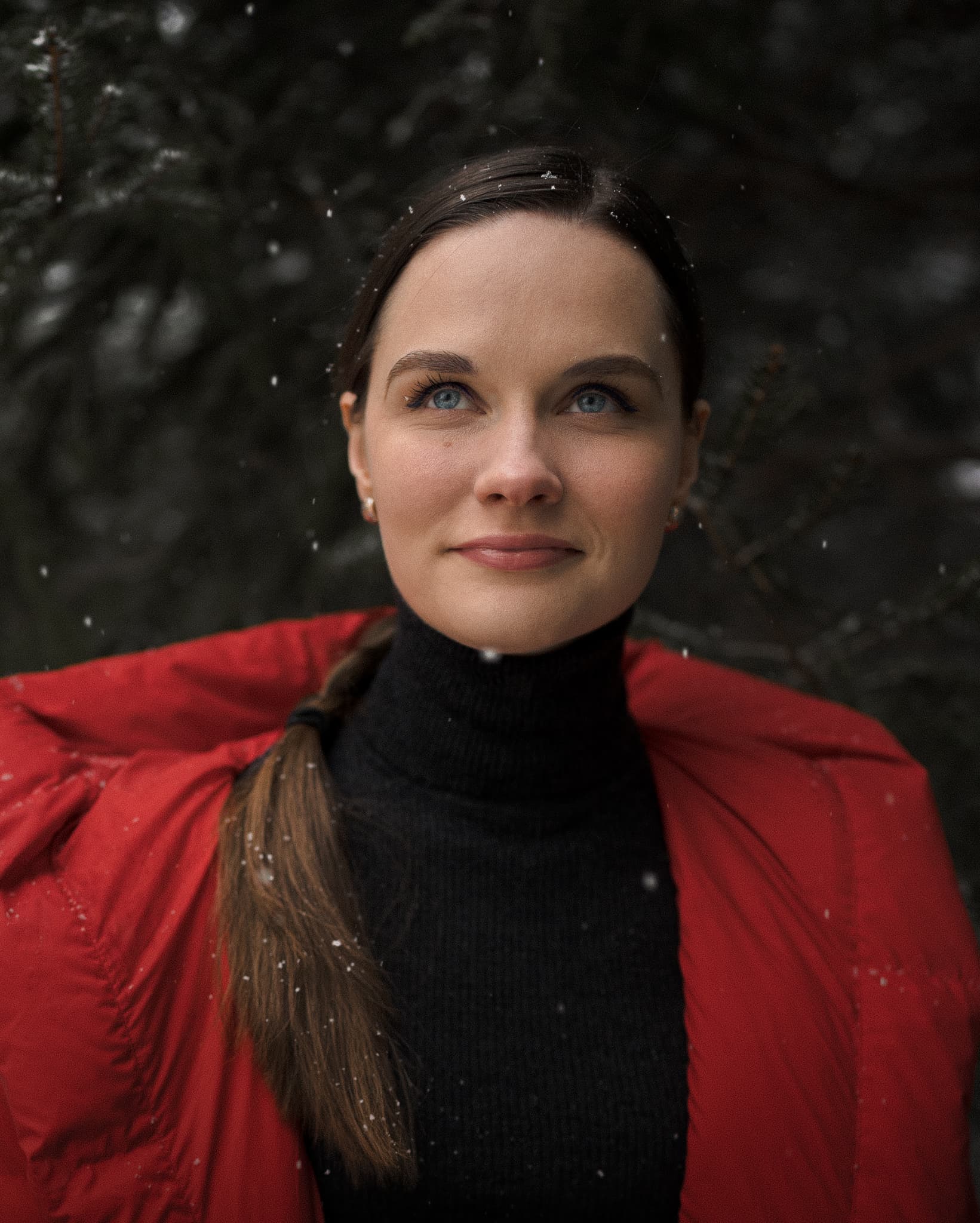 Woman in a red jacket with snowflakes on her hair
